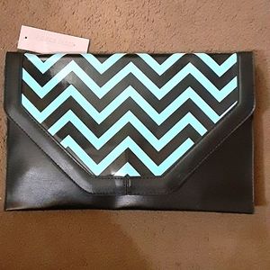 Medium/large size clutch with button flap over patent leather front with zigzag